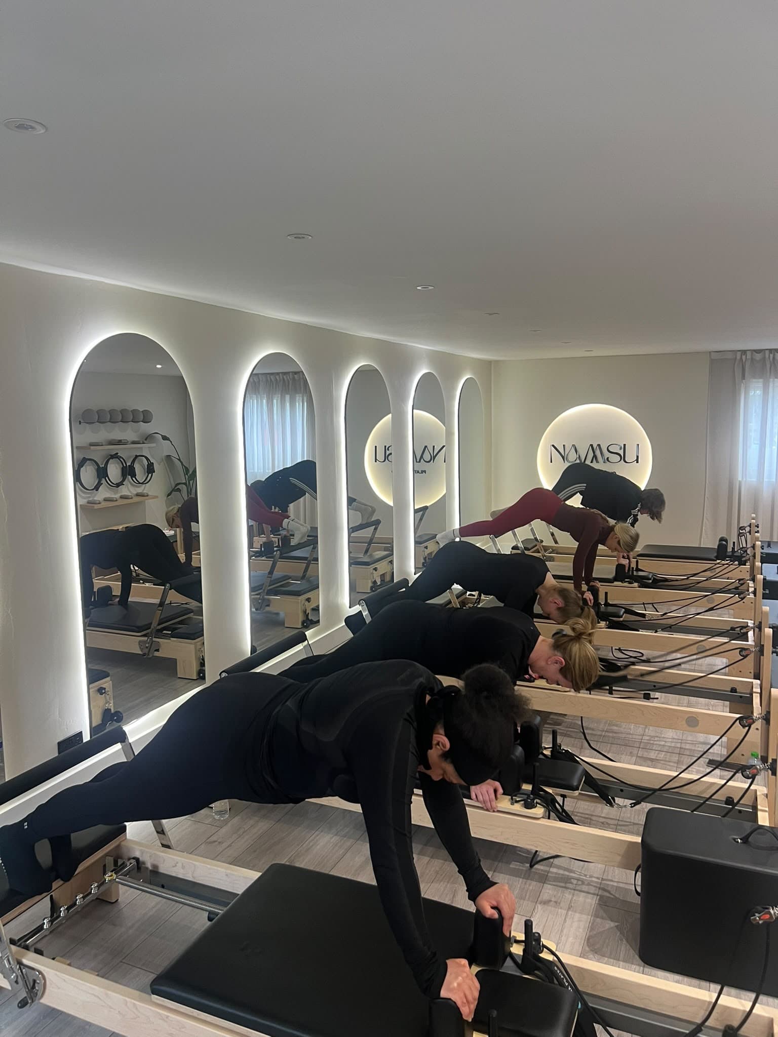 Clients holding a plank during a group class at the studio