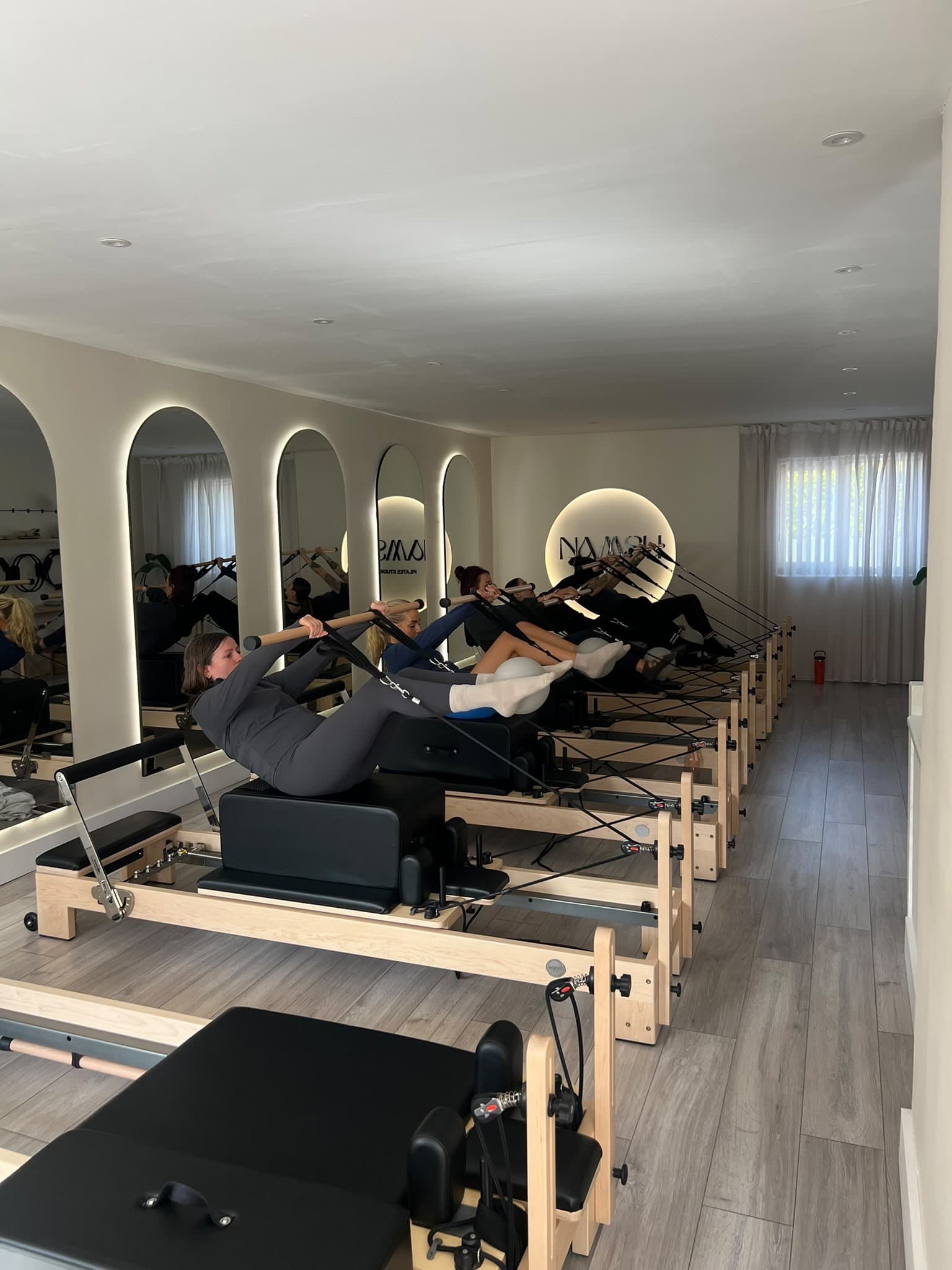 A group class reaching forward with arms extended at the studio